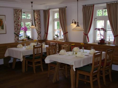 comedor con 2 mesas, sillas y ventanas en Stubersheimer Hof, en Stubersheim
