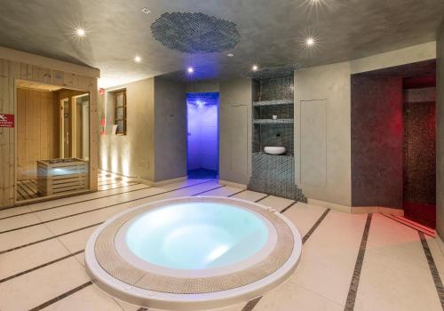 uma grande casa de banho com uma grande banheira no meio em Hotel Edelhof em Tarvisio