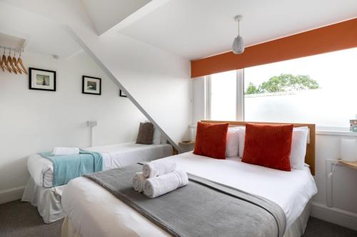 1 dormitorio con 2 camas y ventana en Oasis House, en Falmouth