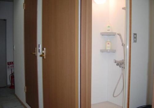 a bathroom with a wooden door and a sink at kawagutiko station inn / Vacation STAY 63735 in Azagawa