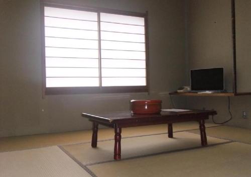 um quarto com uma mesa em frente a uma janela em kawagutiko station inn / Vacation STAY 63732 em Azagawa