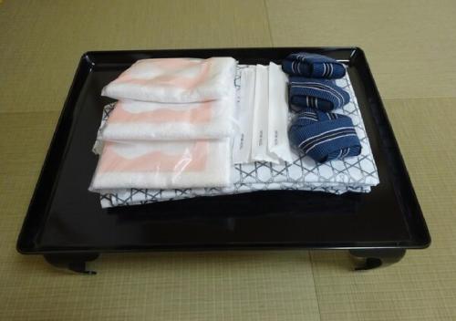 kawagutiko station inn / Vacation STAY 63722 في Azagawa: صينية سوداء مع المناشف على الطاولة