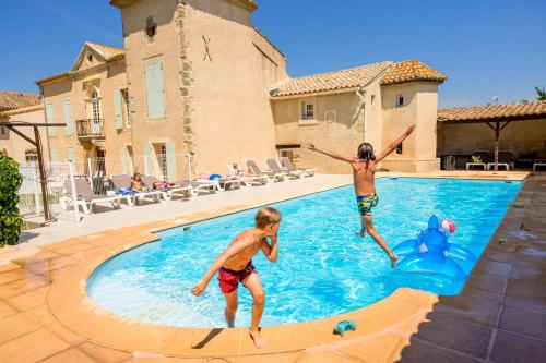 two young children playing in a swimming pool at Domaine de Puychêne in Saint-Nazaire-dʼAude