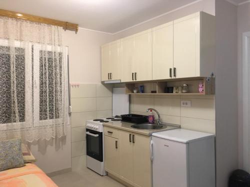 a small kitchen with white cabinets and a sink at Apartment Vistanova in Vrdnik