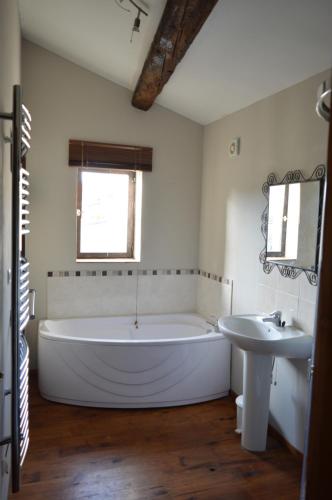 uma casa de banho com uma banheira grande e um lavatório em L'apartement deluxe em Azille