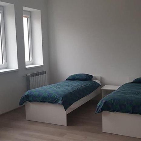 a bedroom with two beds and two windows at Lula in Gołdap