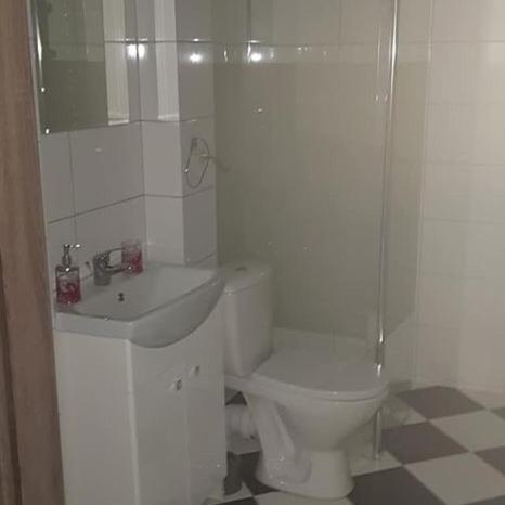 a white bathroom with a toilet and a sink at Lula in Gołdap