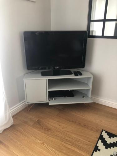 a flat screen tv sitting on a white entertainment center at Appart 2 pièces avec parking QUARTIER DU LAC in Saint-Jean-de-Luz