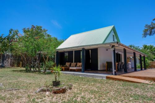 una casa con techo verde en un patio en Villa Blue Lagon... à 100m de la plage!, en La Saline-Les-Bains