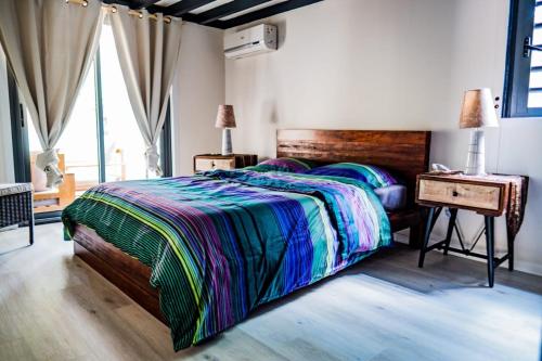 1 dormitorio con 1 cama con cabecero de madera y mesa en Villa Blue Lagon... à 100m de la plage!, en La Saline-Les-Bains