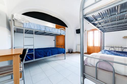 a bedroom with two bunk beds and a desk at Albergue las Veletas in Cáceres
