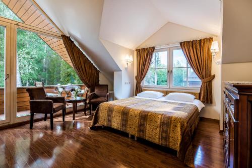 een slaapkamer met een bed en een groot raam bij Villa Avirio Vingis in Druskininkai