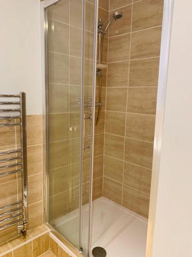 a shower with a glass door in a bathroom at Swandown Hotel in Swindon