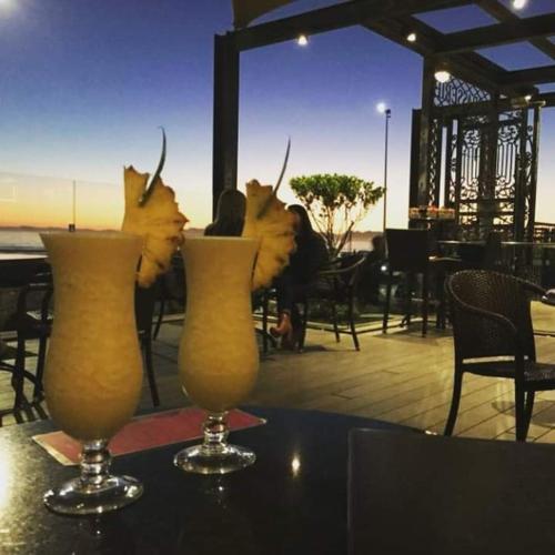 two vases on a table with some drinks on it at Hibernian Towers 807, Beach Road, Strand in Strand