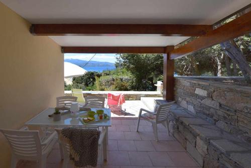 a patio with a table and chairs and a stone wall at Residence Arinella in Farinole