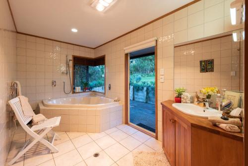 a bathroom with a tub and a sink at Puketotara Lodge in Kerikeri