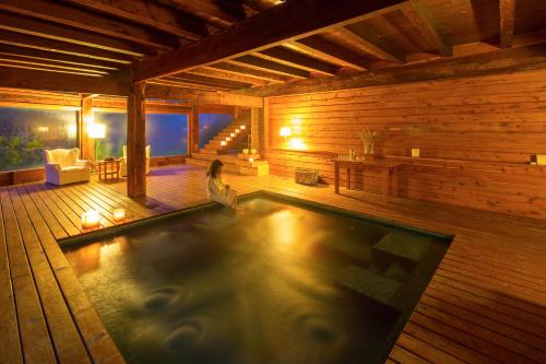 a woman sitting in a swimming pool in a wooden house at Hostería Isla Victoria Lodge in Isla Victoria