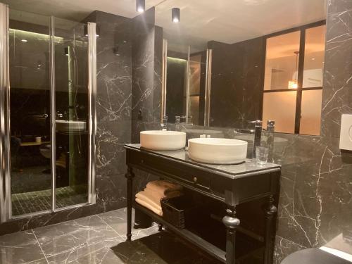a black bathroom with a sink and a shower at VILLA DU CEDRE Honfleur in Honfleur