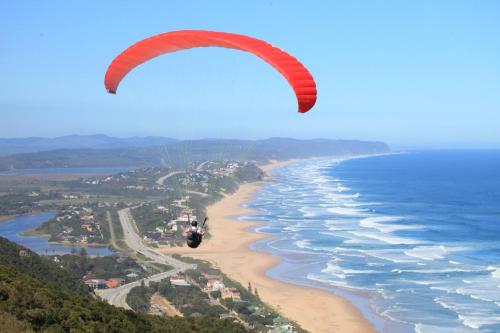 a person flying a parachute over the beach at Wilderness Lake View Self-Catering in Wilderness