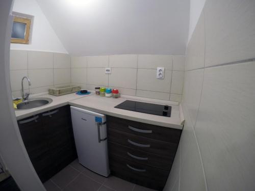a small white kitchen with a sink and a sink at Apartman Vukašin in Kopaonik