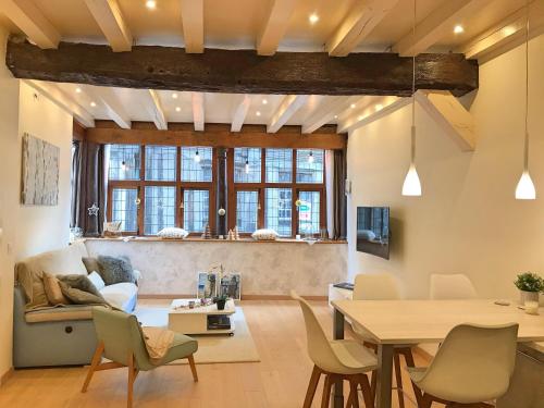 ein Wohnzimmer mit einem Tisch, Stühlen und einem Sofa in der Unterkunft Appartement de charme classé 4 étoiles coeur historique de Dinan in Dinan