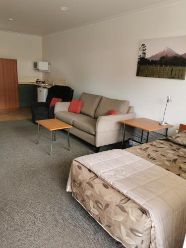 a living room with a bed and a couch at Bks Egmont Motor Lodge in New Plymouth