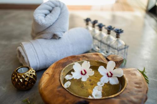 a table with a bowl with white flowers on it at Monte da Estrela - Country House & SPA in Moura