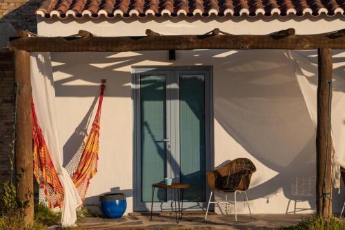 a porch with a green door and two chairs at Monte da Estrela - Country House & SPA in Moura