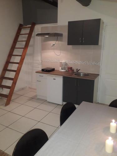 kuchnia ze stołem i krzesłami oraz schody w obiekcie studio Aude w mieście Lézignan-Corbières