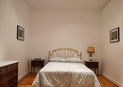 a bedroom with a bed and two night stands and two tables at Casa burguesa de 1900 in Valladolid