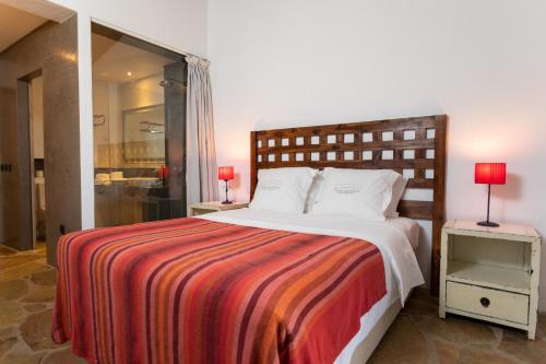 a bedroom with a large bed with a striped blanket at Monte da Estrela - Country House & SPA in Moura