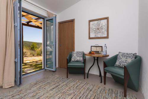 a room with two chairs and a table and a sliding glass door at Monte da Estrela - Country House & SPA in Moura