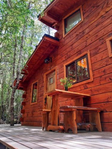 a log cabin with a picnic table in front of it at Cabañas Bosque Milenario in Coñaripe