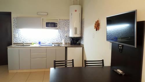 una cocina con mesa y TV. en Pachamama - Depto p/4 nuevo y a 5' del centro en Salta