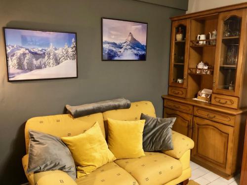 a living room with a yellow couch with pillows at Anayet Sweet Home in Formigal