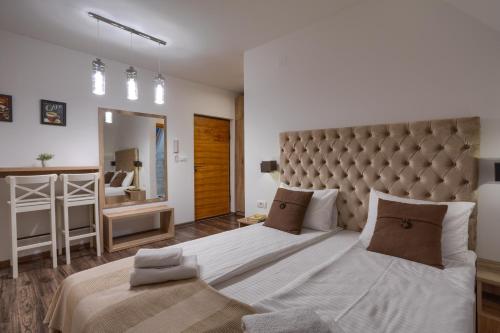 a bedroom with a large bed and a large mirror at All Seasons Residence in Zlatibor