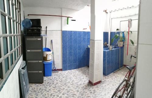 a bathroom with a shower and a sink and blue tiles at Casa de Descanso Marrón 101 in Villavicencio