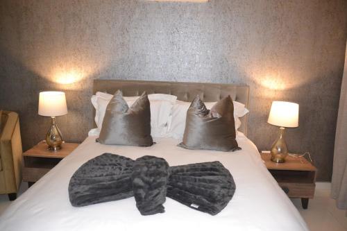a bed with a robe on it with two lamps at Prisatt Boutique Hotel in Onverwacht