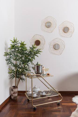 a tea cart with dishes and a plant on a wall at Suite room in Aversa