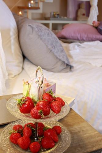 two plates of strawberries on a table next to a bed at Princess No3 Self Check-In Plochingen bei Stuttgart in Plochingen
