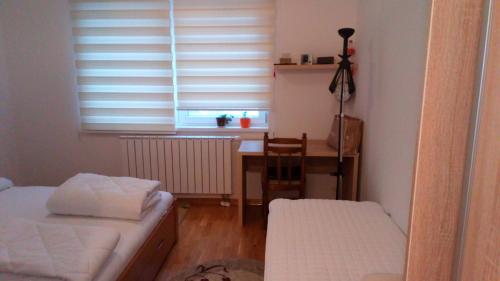 een kamer met een bed, een bureau en een raam bij Sarajevo Olympic City in Sarajevo