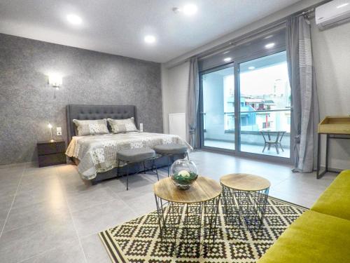 a bedroom with a bed and a large window at Dreamstudio in the city center in Volos