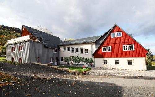 a red and white building with a red roof at FeWo Skiheim in Großschönau