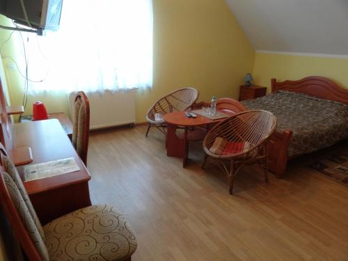 チェホチネクにあるWilla Pod Jedlicąのベッド、テーブル、椅子が備わる客室です。