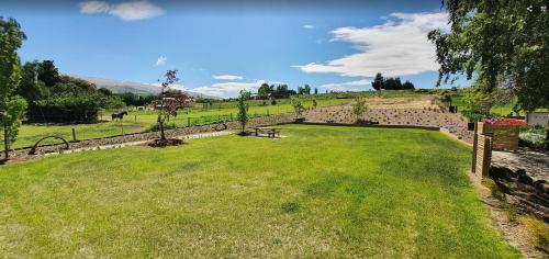 a park with a bench in a grass field at Roxburgh Clutha Gold TOP 10 Holiday Park in Roxburgh