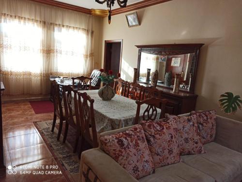 ein Wohnzimmer mit einem Tisch, Stühlen und einem Sofa in der Unterkunft The Red Rose City in Wadi Musa