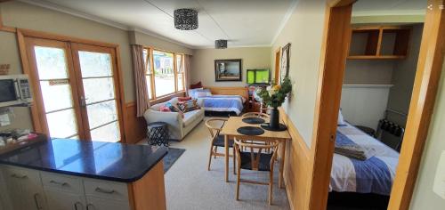 eine Küche und ein Wohnzimmer mit einem Bett und einem Tisch in der Unterkunft Roxburgh Clutha Gold TOP 10 Holiday Park in Roxburgh