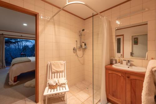 a bathroom with a shower and a sink at Puketotara Lodge in Kerikeri
