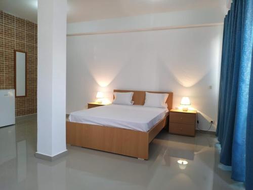 a bedroom with a bed and two night stands with lamps at Plateau Bedroom & Chambre - Praia Center 1 in Praia