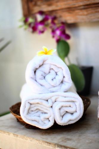 a pile of towels sitting on a table at Villa D'Uma in Ubud